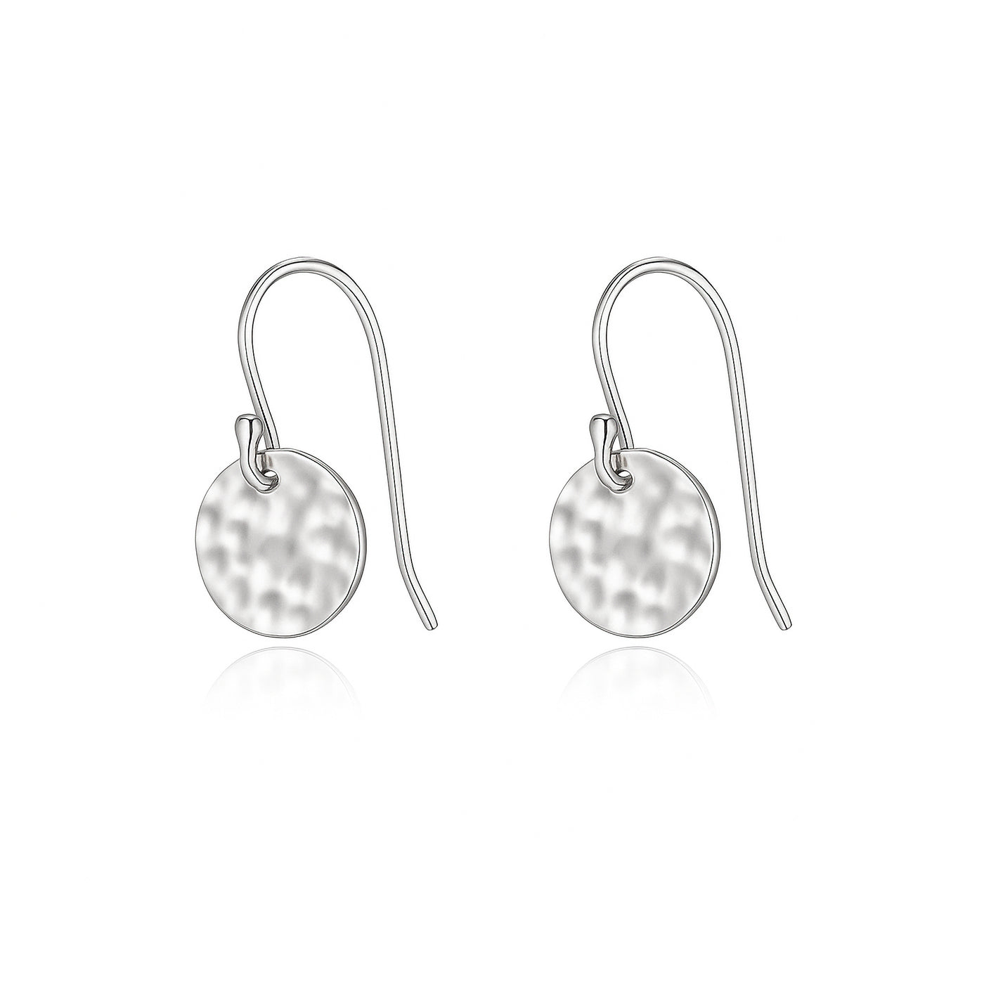 Pair of silver earrings with round, hammered discs on a white background — jewellery detail
